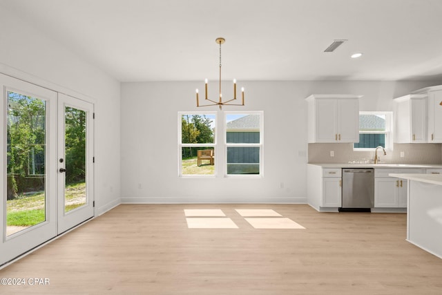 kitchen featuring light hardwood / wood-style floors, stainless steel dishwasher, pendant lighting, and white cabinets