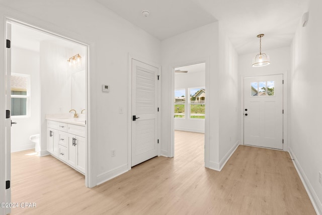 entryway with baseboards and light wood-style floors