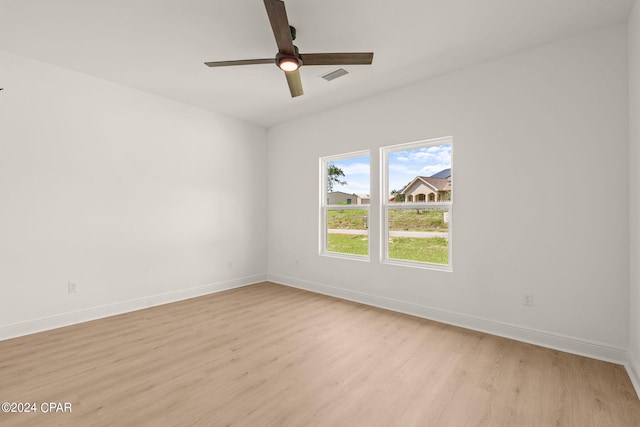 empty room with light wood-style flooring, ceiling fan, baseboards, and visible vents