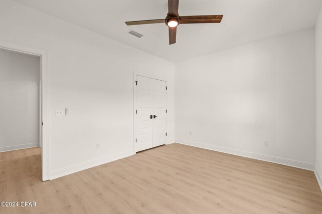unfurnished bedroom featuring a closet, baseboards, light wood-style flooring, visible vents, and ceiling fan
