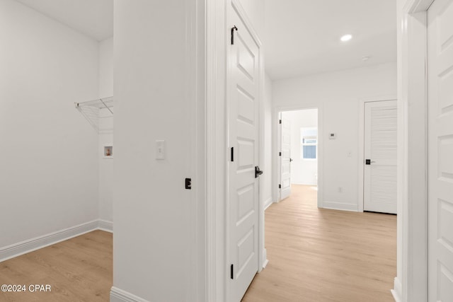 hall featuring light wood-style flooring, recessed lighting, and baseboards
