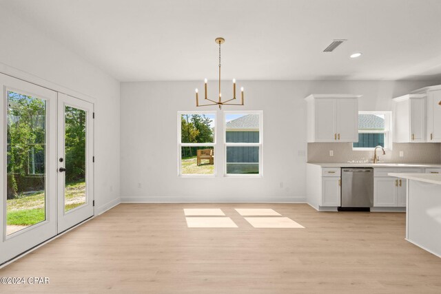 kitchen featuring dishwasher, light wood-type flooring, white cabinetry, and decorative light fixtures