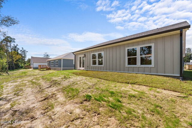 rear view of property featuring a yard and a wooden deck