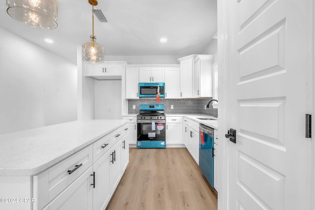 kitchen featuring sink, stainless steel appliances, decorative light fixtures, decorative backsplash, and white cabinets