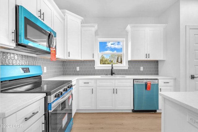 kitchen with white cabinetry, sink, stainless steel appliances, backsplash, and light wood-type flooring