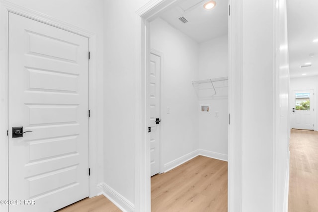 laundry area with hookup for a washing machine and light hardwood / wood-style flooring