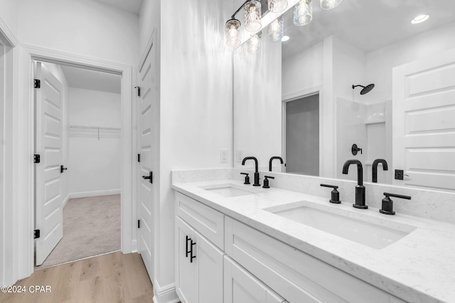 bathroom featuring wood-type flooring, vanity, and walk in shower