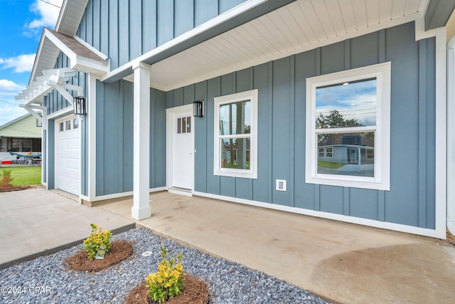 entrance to property featuring covered porch and a garage