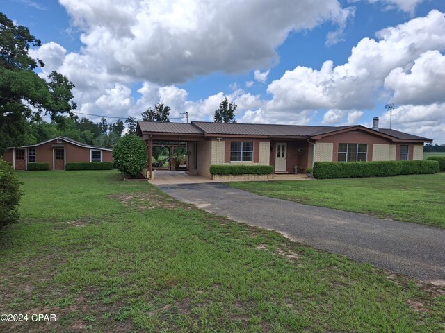 ranch-style house featuring a carport and a front lawn