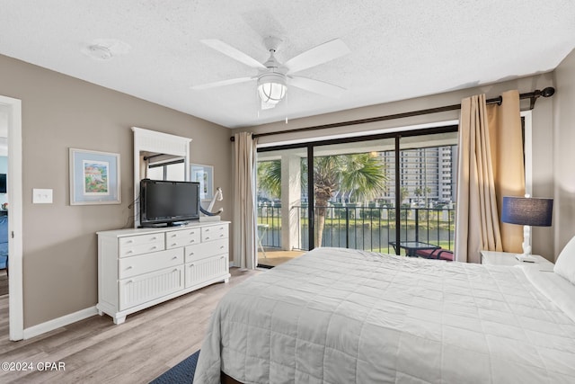 bedroom featuring access to exterior, ceiling fan, light hardwood / wood-style flooring, and a textured ceiling