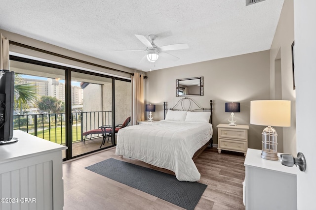 bedroom featuring access to exterior, a textured ceiling, light wood-type flooring, and ceiling fan