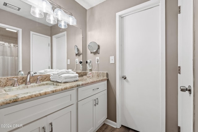 bathroom with a textured ceiling, vanity, a shower with curtain, and hardwood / wood-style floors