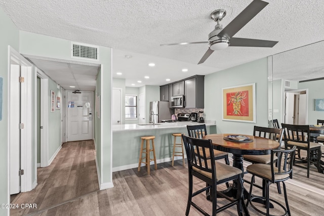 dining space featuring dark hardwood / wood-style floors, ceiling fan, and a textured ceiling