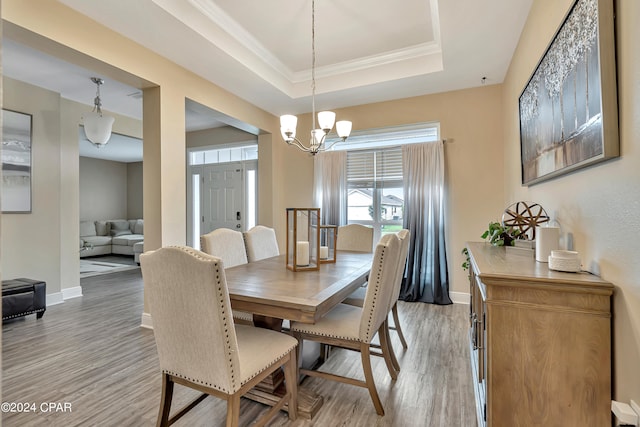 dining room featuring a chandelier, hardwood / wood-style flooring, and a raised ceiling