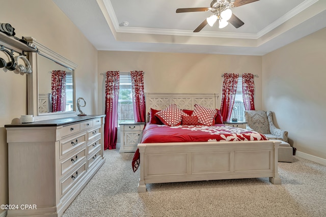 carpeted bedroom featuring ceiling fan, a raised ceiling, and ornamental molding