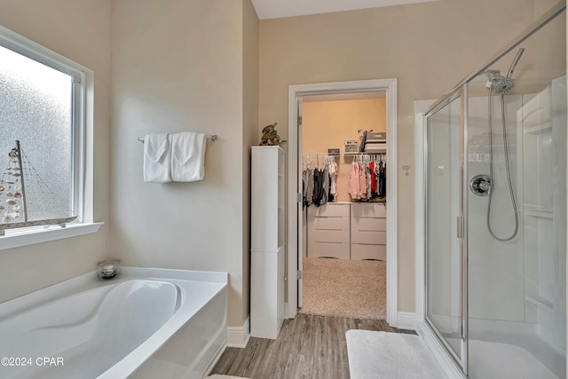 bathroom with hardwood / wood-style flooring, independent shower and bath, and plenty of natural light