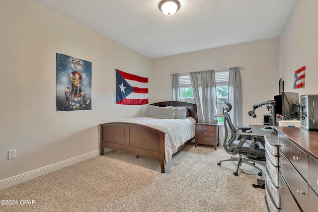 bedroom featuring light colored carpet and a textured ceiling