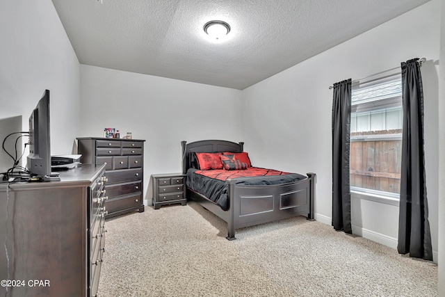 bedroom featuring light colored carpet and a textured ceiling