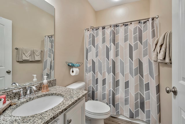 bathroom with a textured ceiling, vanity, toilet, and hardwood / wood-style floors