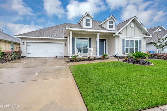 view of front of house with a garage, a front yard, and covered porch