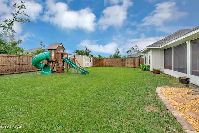 view of yard featuring a storage unit and a playground