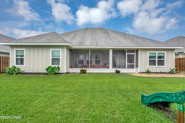 rear view of property featuring a sunroom and a yard