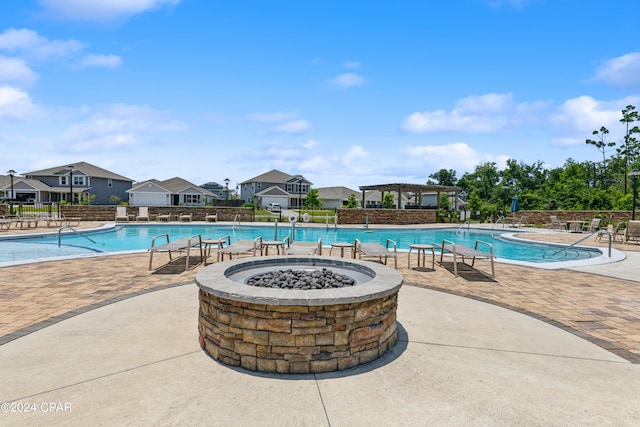 view of swimming pool featuring a fire pit and a patio