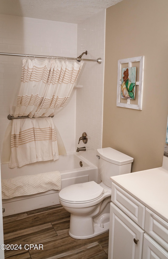 full bathroom with a textured ceiling, shower / tub combo, toilet, and vanity