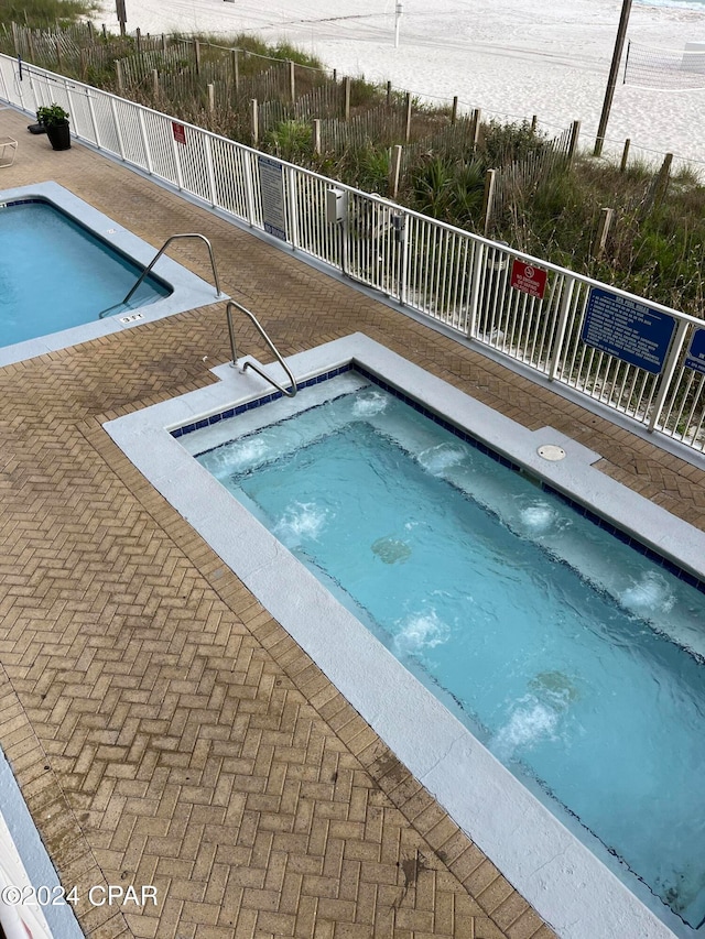 view of swimming pool with a hot tub