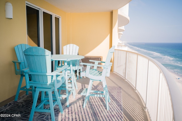 balcony featuring a view of the beach and a water view