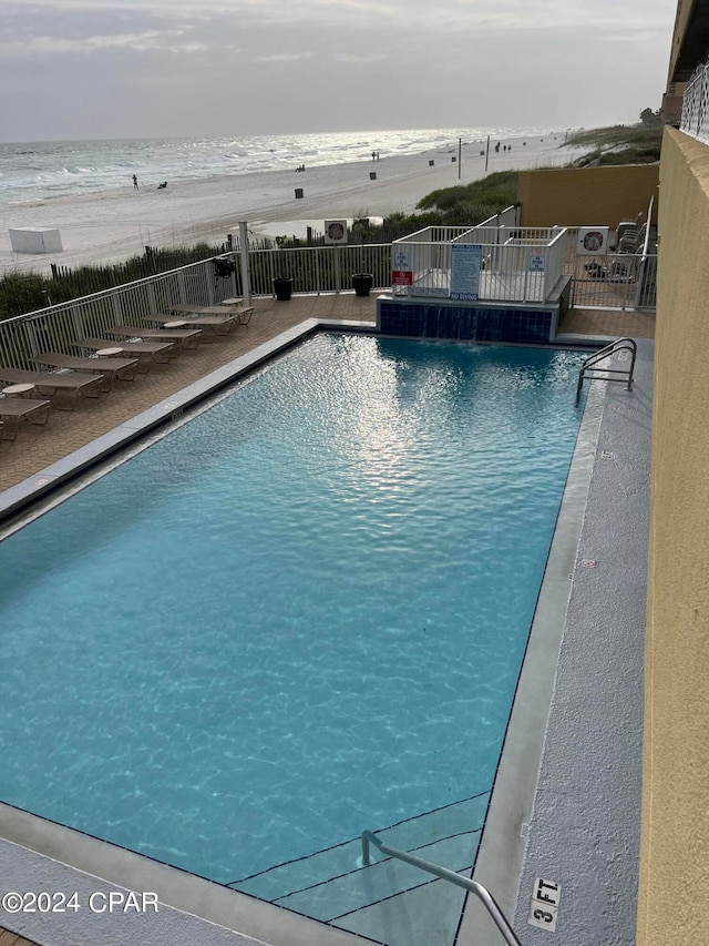 view of pool featuring pool water feature and a water view