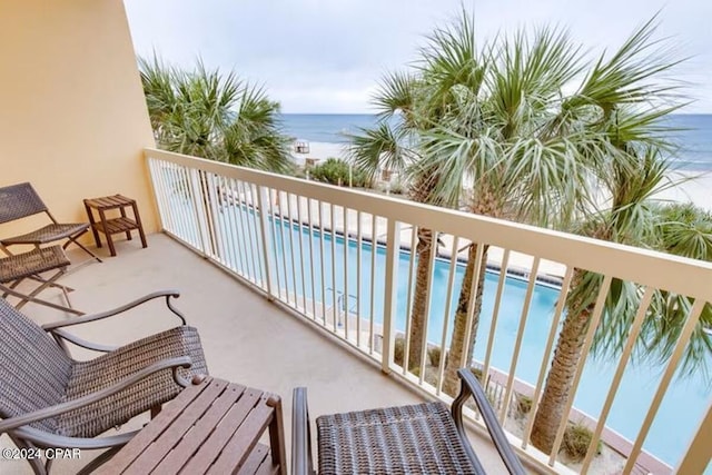 balcony featuring a water view and a beach view