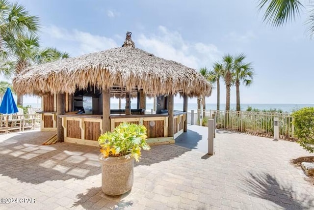 view of patio featuring a water view and exterior bar