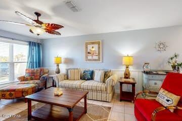 tiled living room with ceiling fan