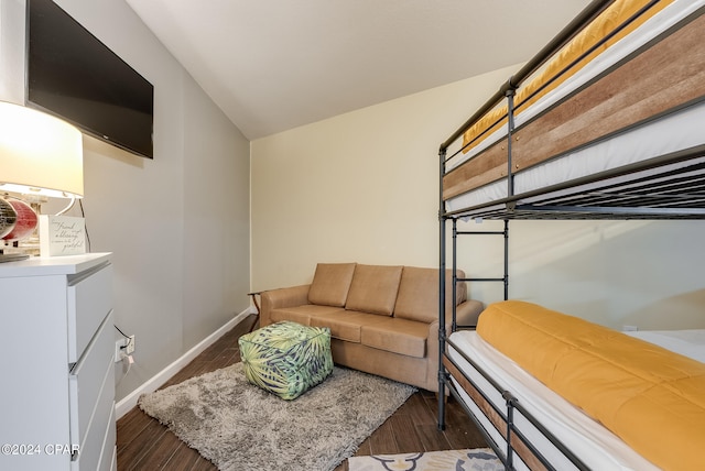 bedroom with vaulted ceiling and dark wood-type flooring