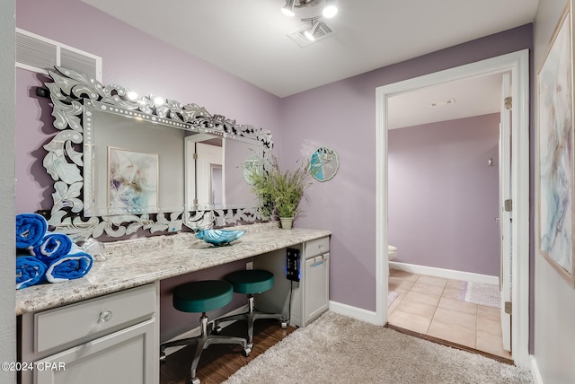 bathroom featuring vanity, toilet, and hardwood / wood-style flooring