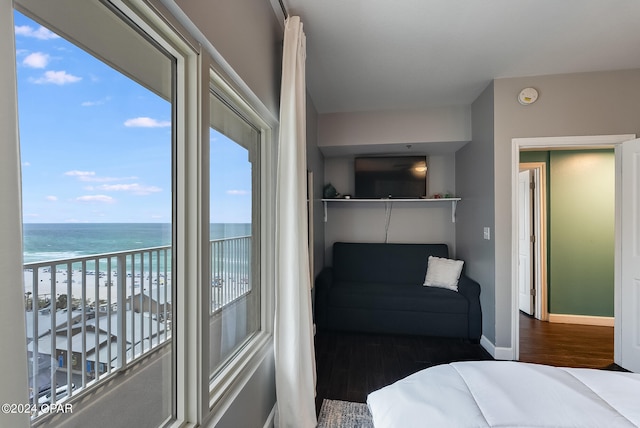 bedroom with a water view and dark wood-type flooring