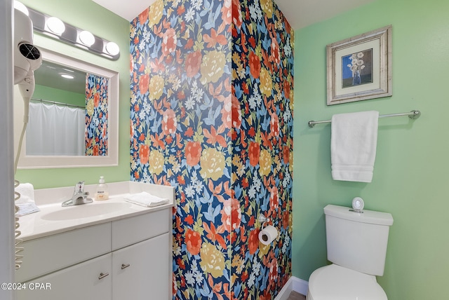 bathroom featuring vanity with extensive cabinet space and toilet