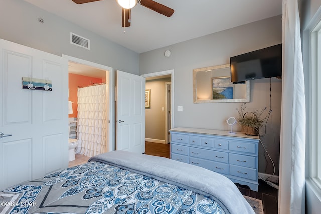 bedroom with wood-type flooring, ceiling fan, and ensuite bath