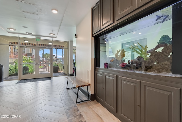 interior space with dark stone counters, french doors, and dark brown cabinetry