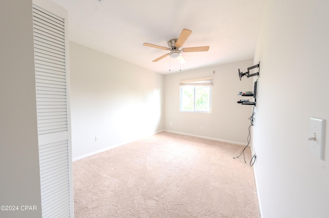 spare room featuring ceiling fan and light colored carpet