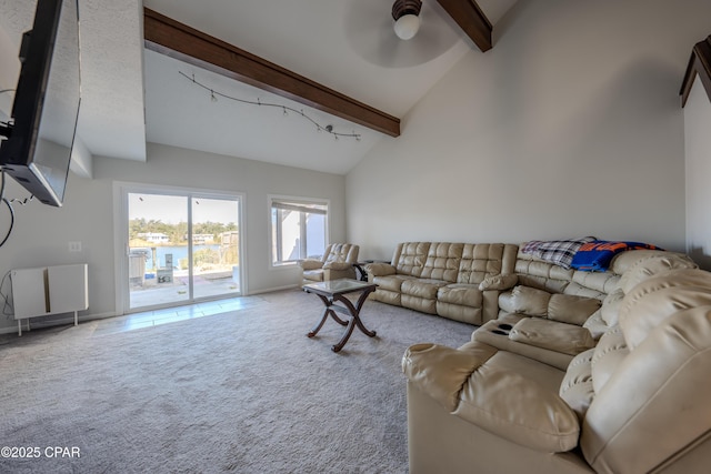 carpeted living room with beamed ceiling, ceiling fan, and high vaulted ceiling