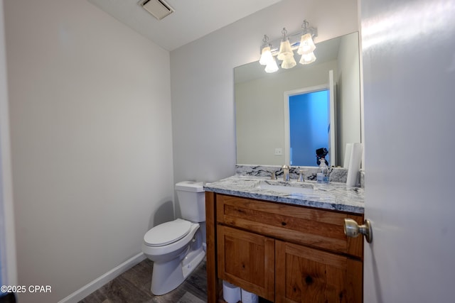 bathroom featuring wood-type flooring, vanity, and toilet