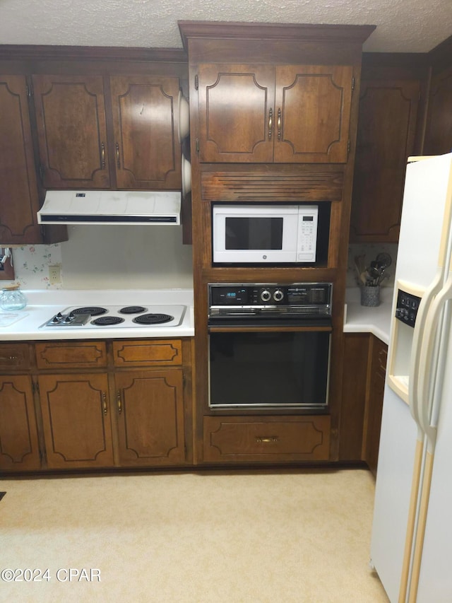 kitchen featuring white appliances, dark brown cabinetry, a textured ceiling, and light carpet