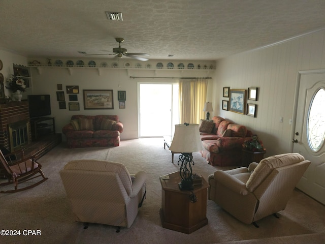 living room featuring carpet floors, ceiling fan, and a textured ceiling