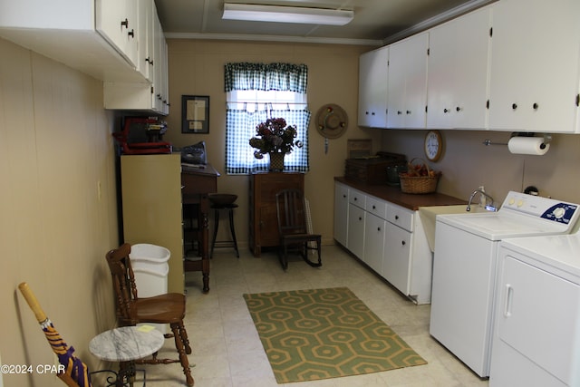 washroom with crown molding, separate washer and dryer, and cabinets