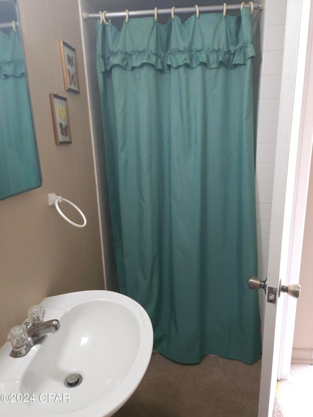 bathroom with sink and a shower with shower curtain