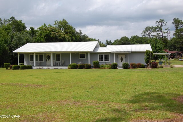 ranch-style home featuring a front lawn and covered porch