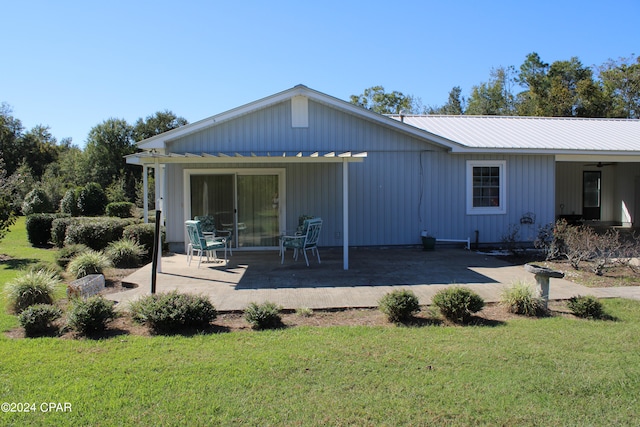 back of house featuring a lawn and a patio area