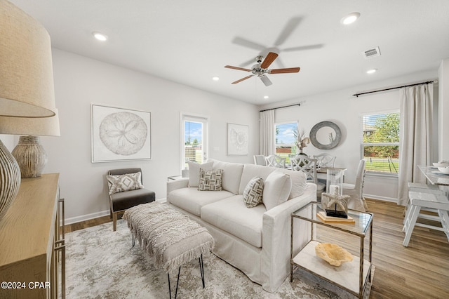 living room with ceiling fan, a wealth of natural light, and hardwood / wood-style floors